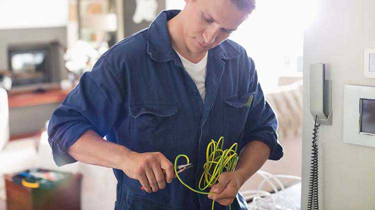 Electricista profesional inspeccionando cables.