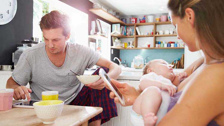 Joven pareja y su bebé están juntos en la cocina de su casa