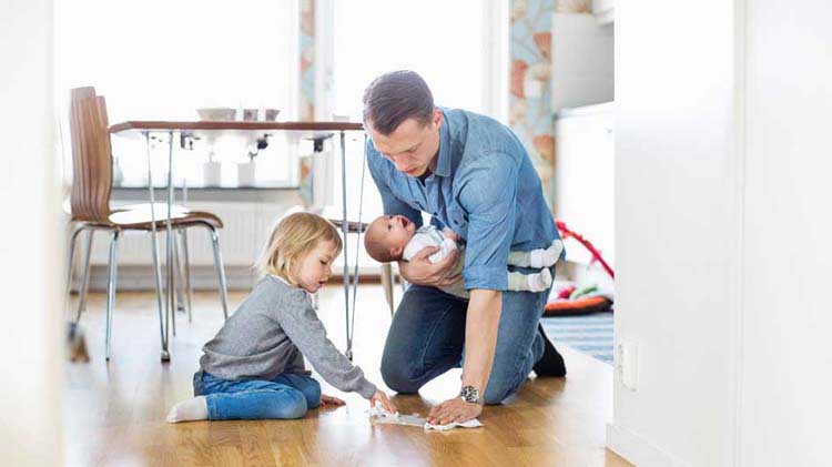 Un padre practica la seguridad en el hogar ayudando a su hija a limpiar un derrame.