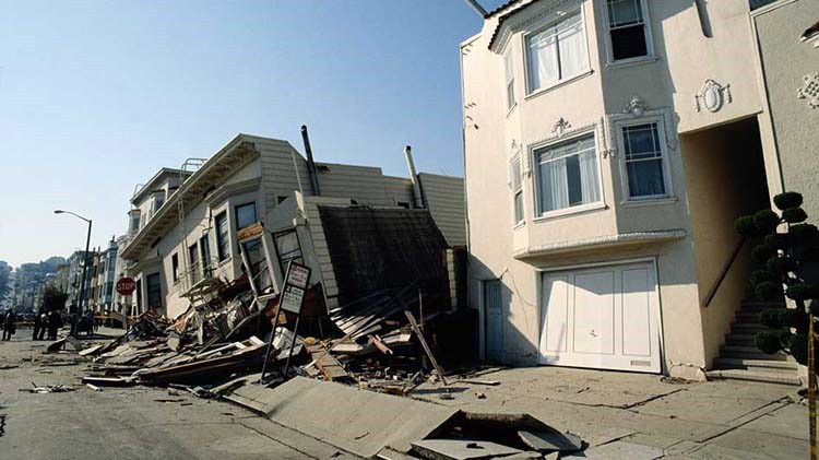 Casas con daños por terremoto, una de ellas inclinada hacia la izquierda y hundida.