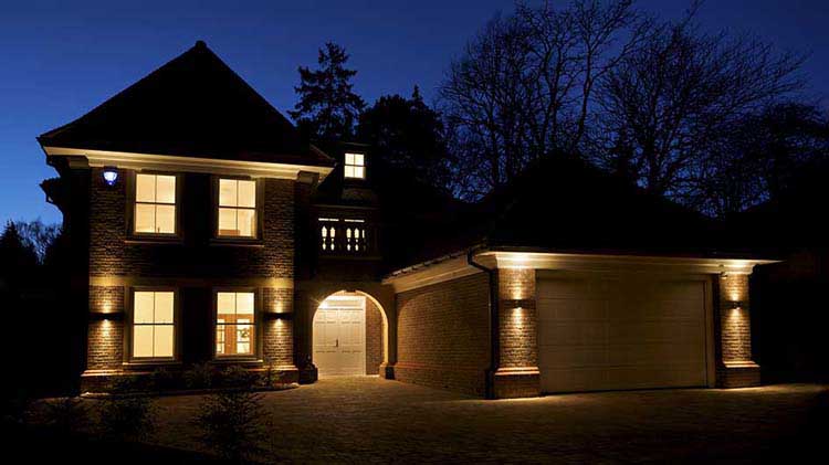 Una casa por la noche con luces interiores y exteriores encendidas