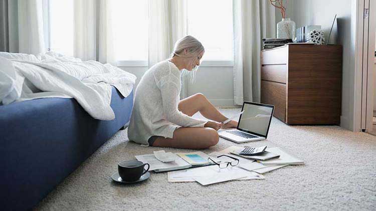 Mujer en la computadora portátil con papeles.