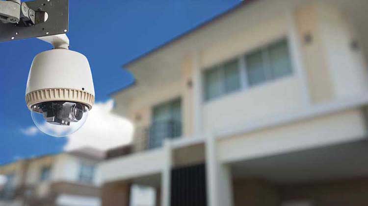 Una cámara de monitoreo remoto para viviendas instalada en el exterior de un edificio residencial.