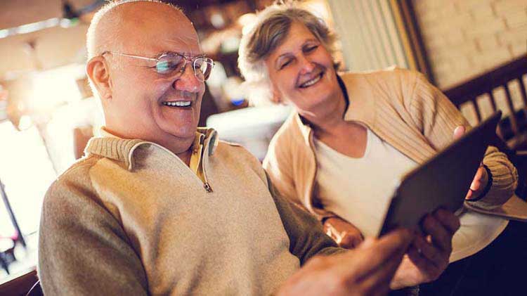 La pareja mayor mira la información en un dispositivo de tableta.
