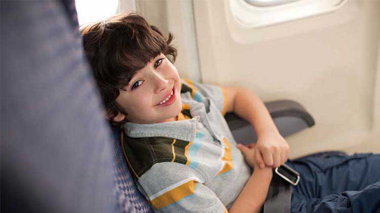 Niño sentado en un asiento de un avión.