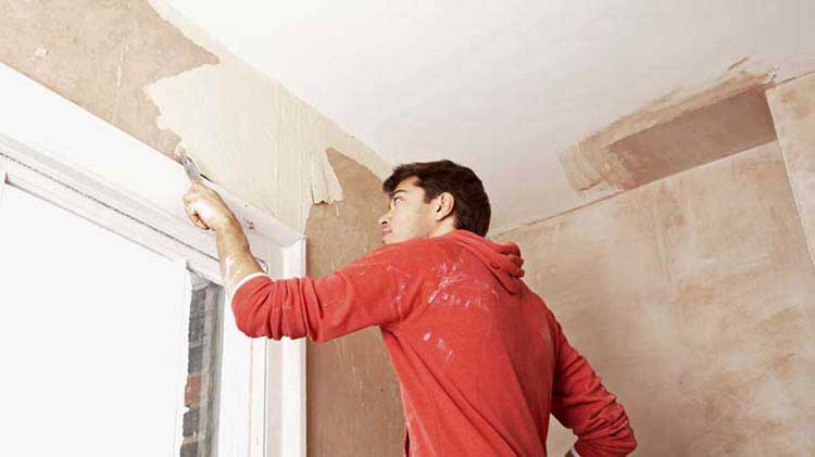 Contratista pintando una pared después de eliminar la pintura con plomo de manera segura