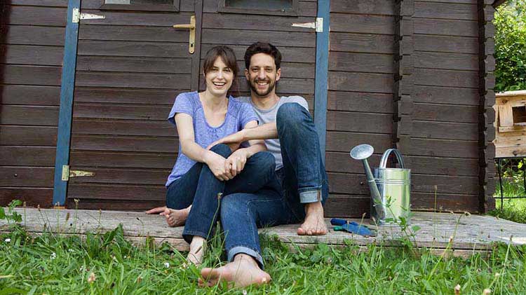 Joven pareja descalza en el patio trasero