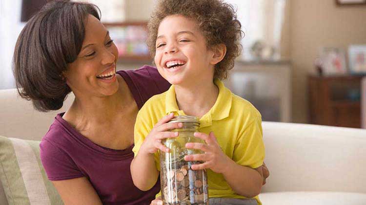 Madre y niño pequeño sostienen una jarra con monedas.