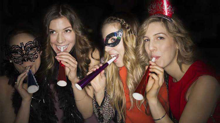 Chicas celebrando en una fiesta de fin de año.