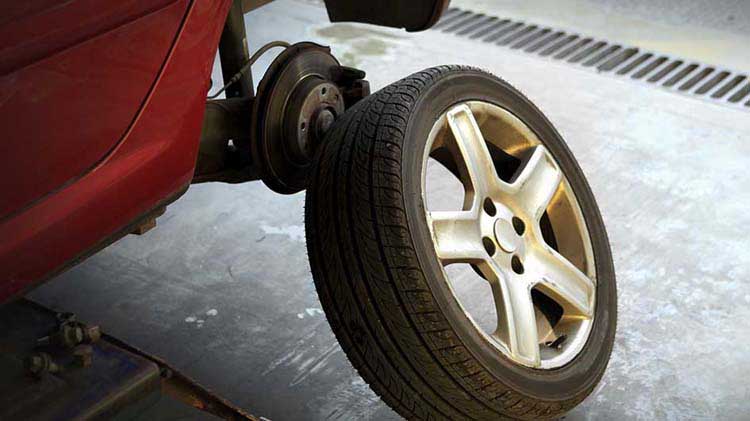 Se retira un neumático de automóvil para mostrar los frenos debajo.