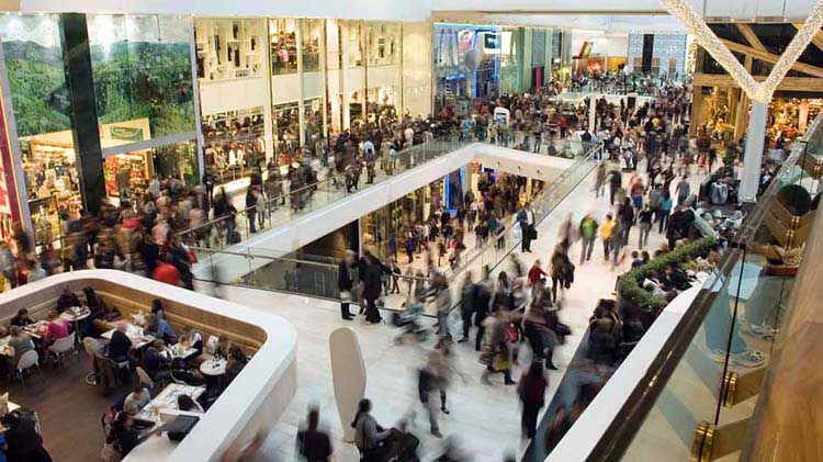 Multitudes de personas comprando en días festivos en un centro comercial.