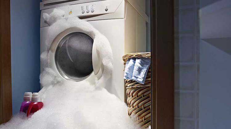 Espuma de agua jabonosa se desborda de una lavadora
