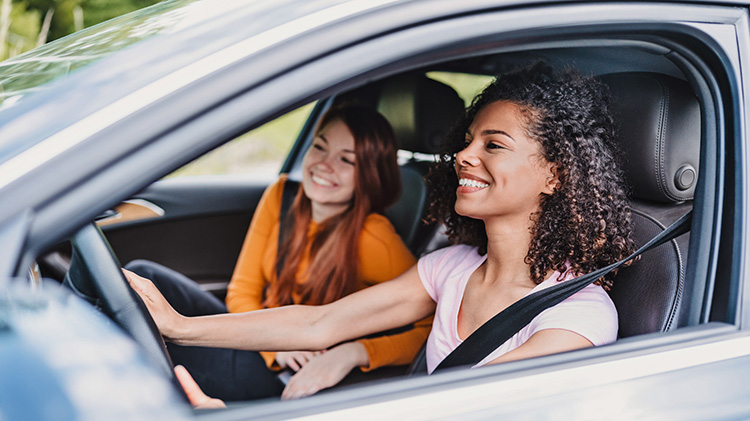 Dos jóvenes compañeras de cuarto viajan en carro.