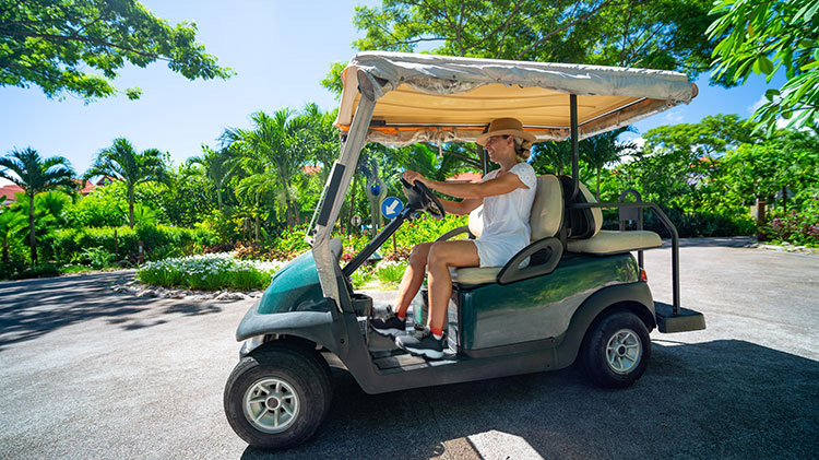 Una golfista en un carrito de golf considerando la necesidad del seguro de carritos de golf.