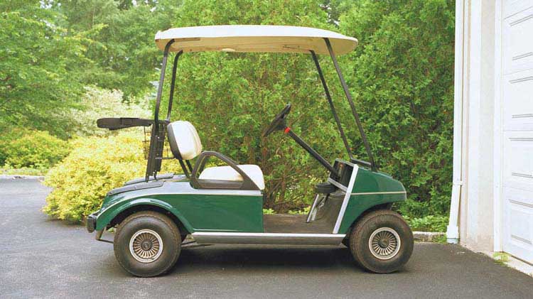 Un carrito de golf estacionado en frente de un garaje.