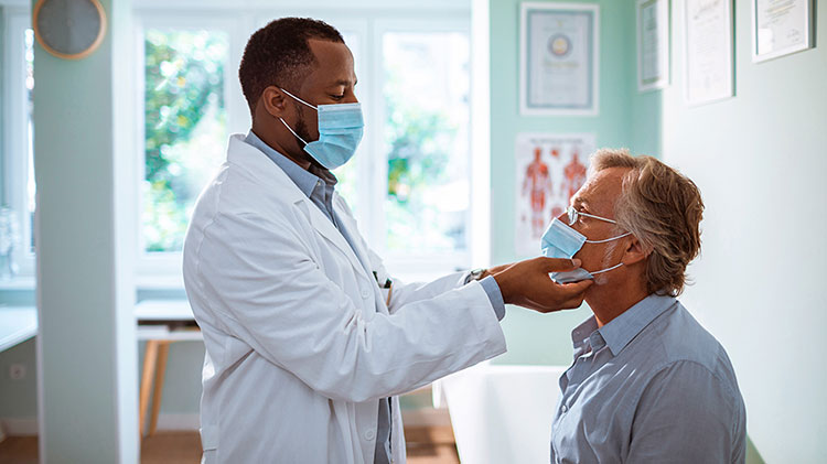 Un médico con una máscara está tocando la cara de su paciente.