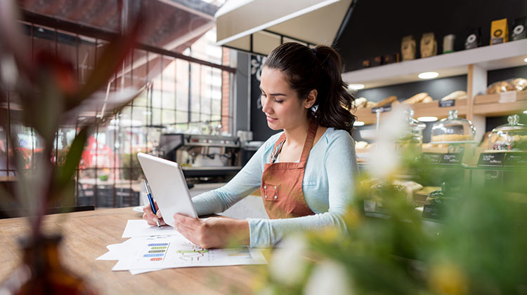 Mujer revisando un plan de negocios para una pequeña empresa.