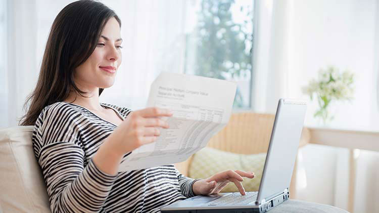 Mujer creando un presupuesto y administrando gastos en su computadora portátil.