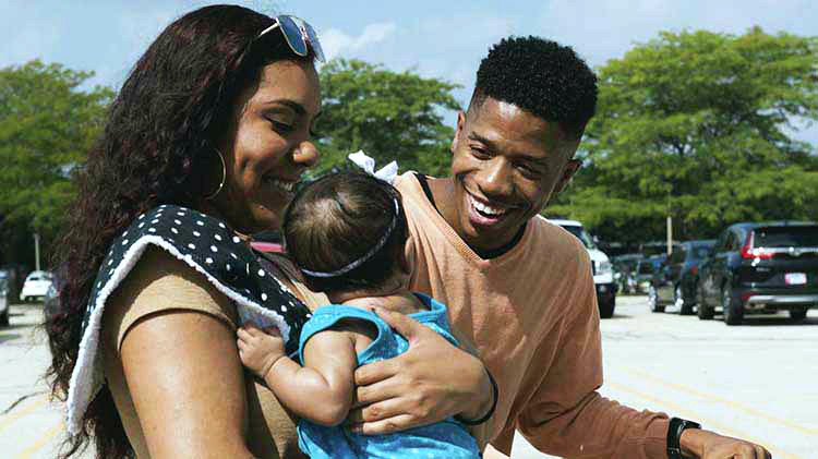 Un hombre y una mujer sujetando a un bebé.