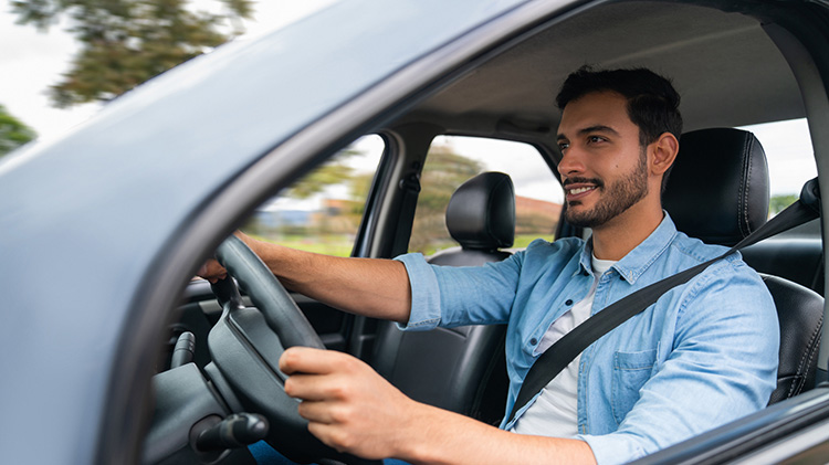 Un hombre maneja un carro.