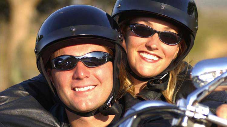 Una pareja viajando en motocicleta de manera segura.