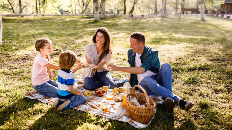 Una familia feliz disfruta de un pícnic en el parque.