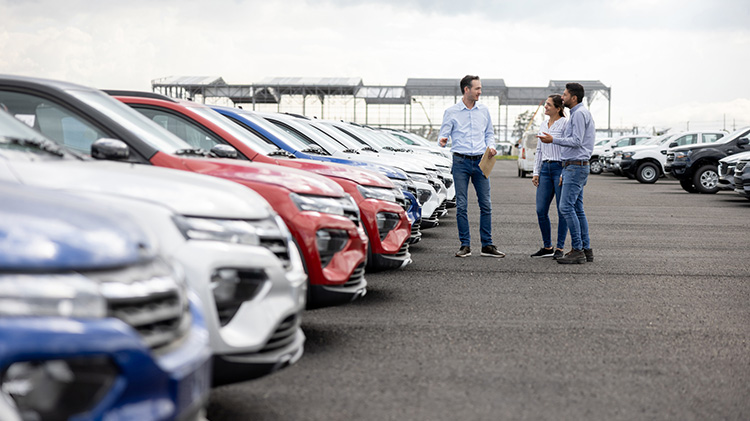 Una pareja en un concesionario buscando un carro.