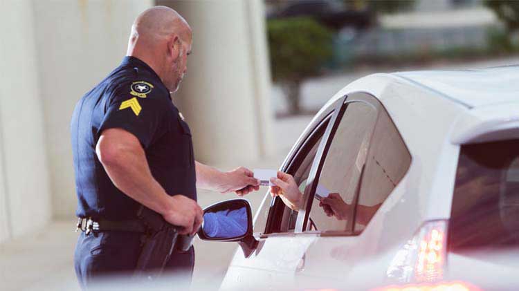 Un policía agarra la licencia de manejo de un conductor.