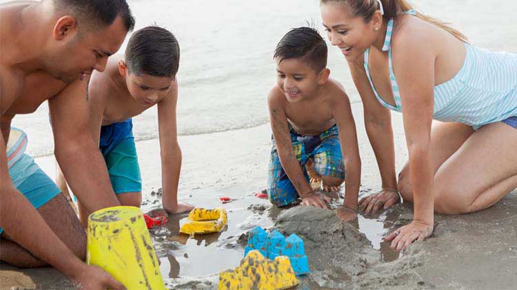 Familia jugando en la arena de la playa.