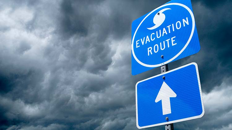 Señal de ruta de evacuación de huracanes con nubes de tormenta.