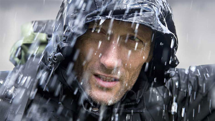 Un hombre con poncho de lluvia durante una tormenta.