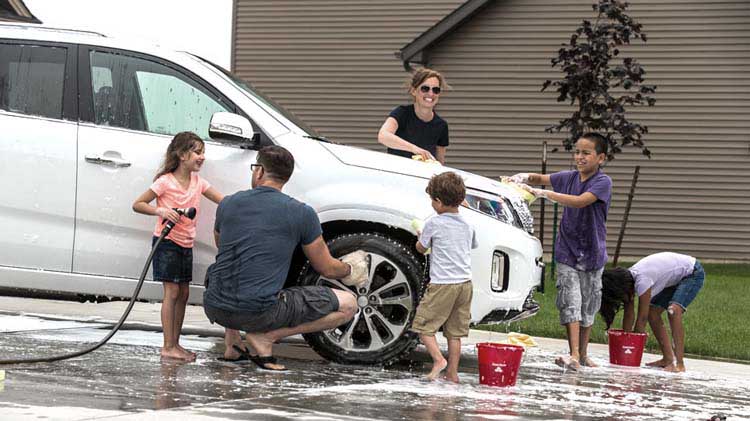 Familia lavando el carro todos juntos.