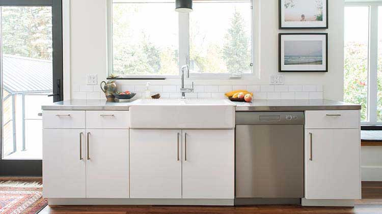 Mostrador de cocina con fregadero, lavadora de platos y gabinetes en la parte inferior.