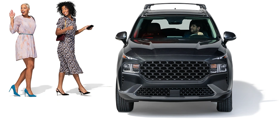 Un par de mujeres se dirigen hacia su conductor, que está esperando en un SUV negro.