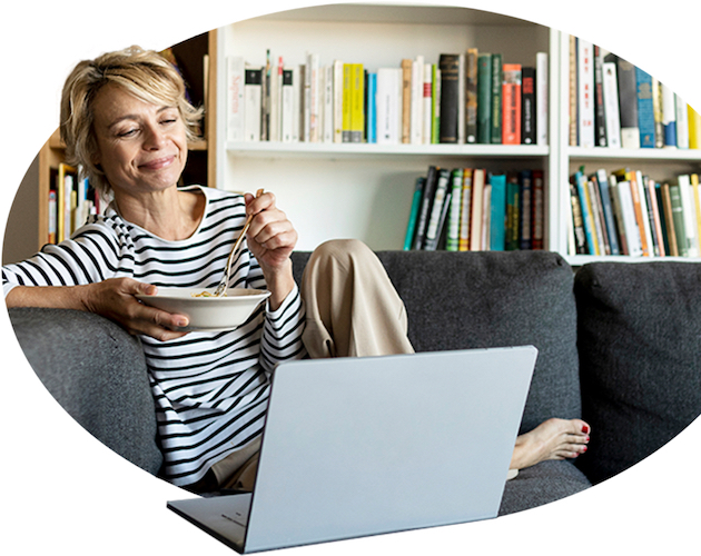 Una mujer habla con su agente a través de su computadora portátil mientras desayuna y se relaja.